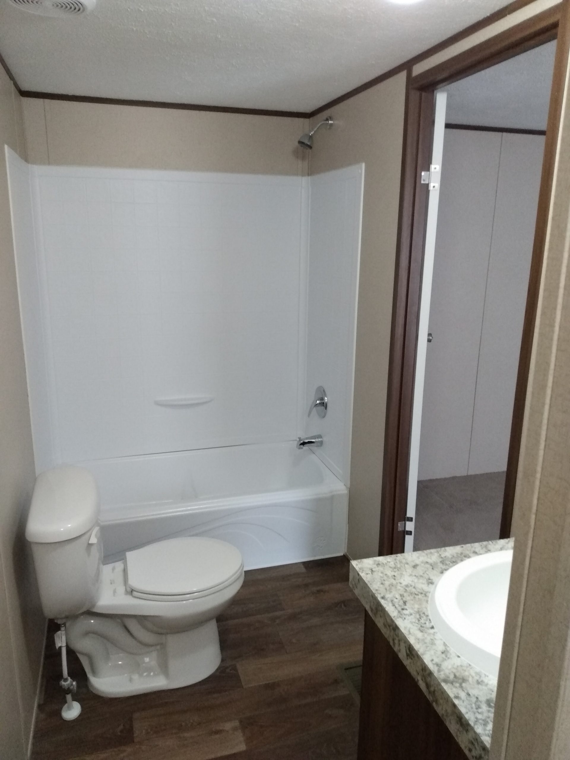 Bathroom with a tub-shower combination, toilet and vanity