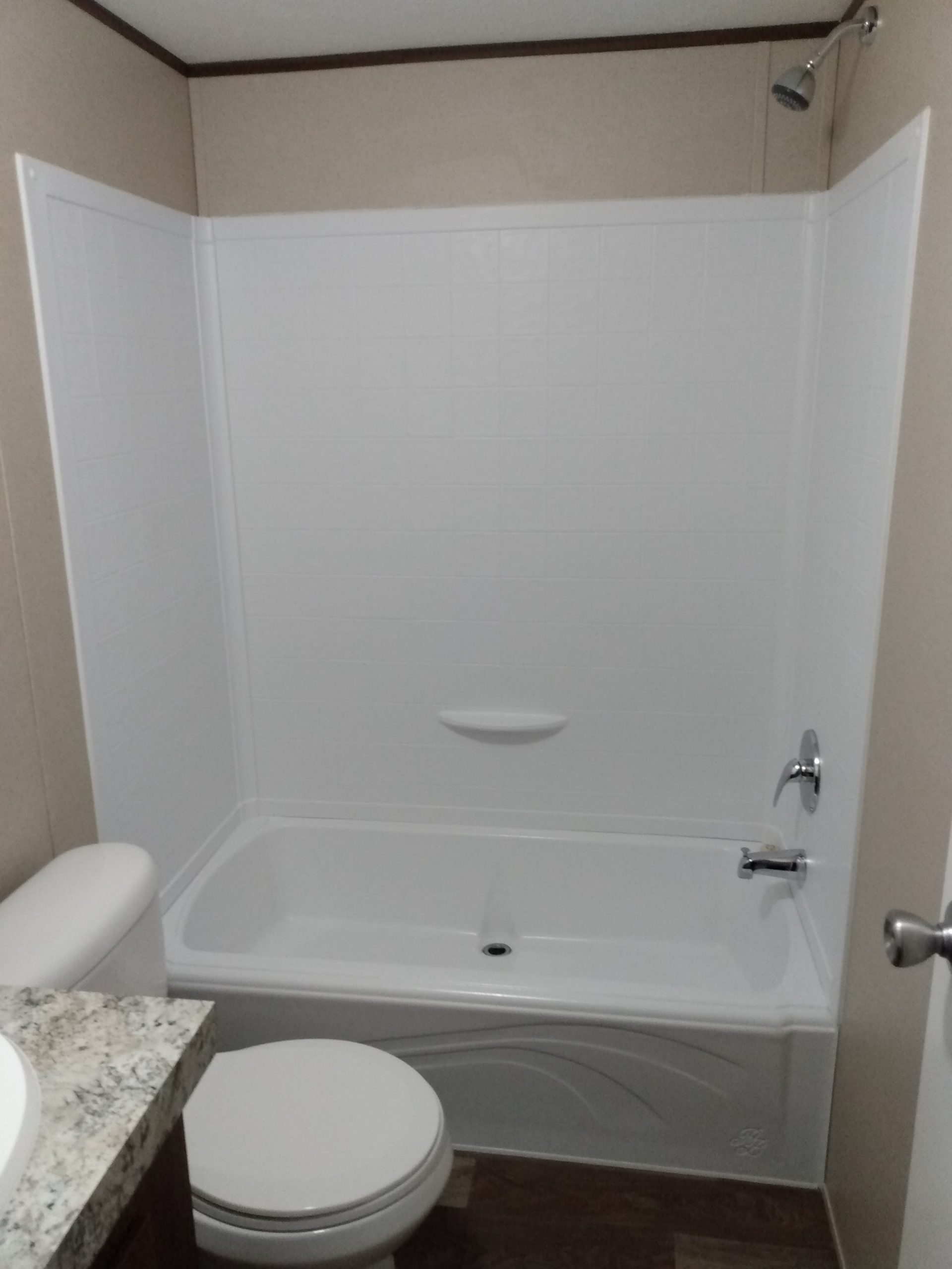 Bathroom with a tub-shower combination and toilet
