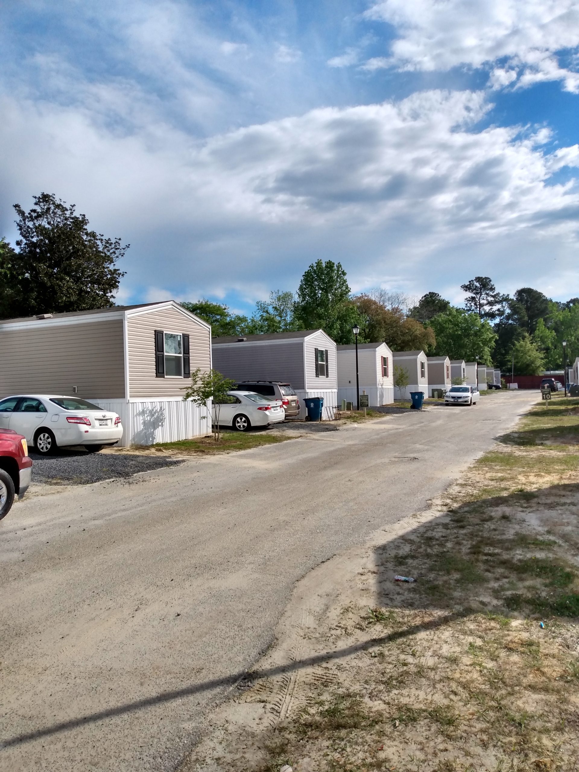 Street view of the community with mobile homes and parked cars